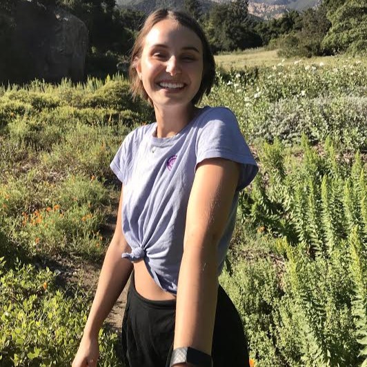 Former computational neuroscience research assistant Meg in a field on grassy mountain