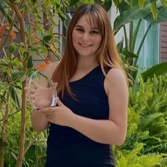 Headshot of research assistant Shelbie holding a transparent glass award