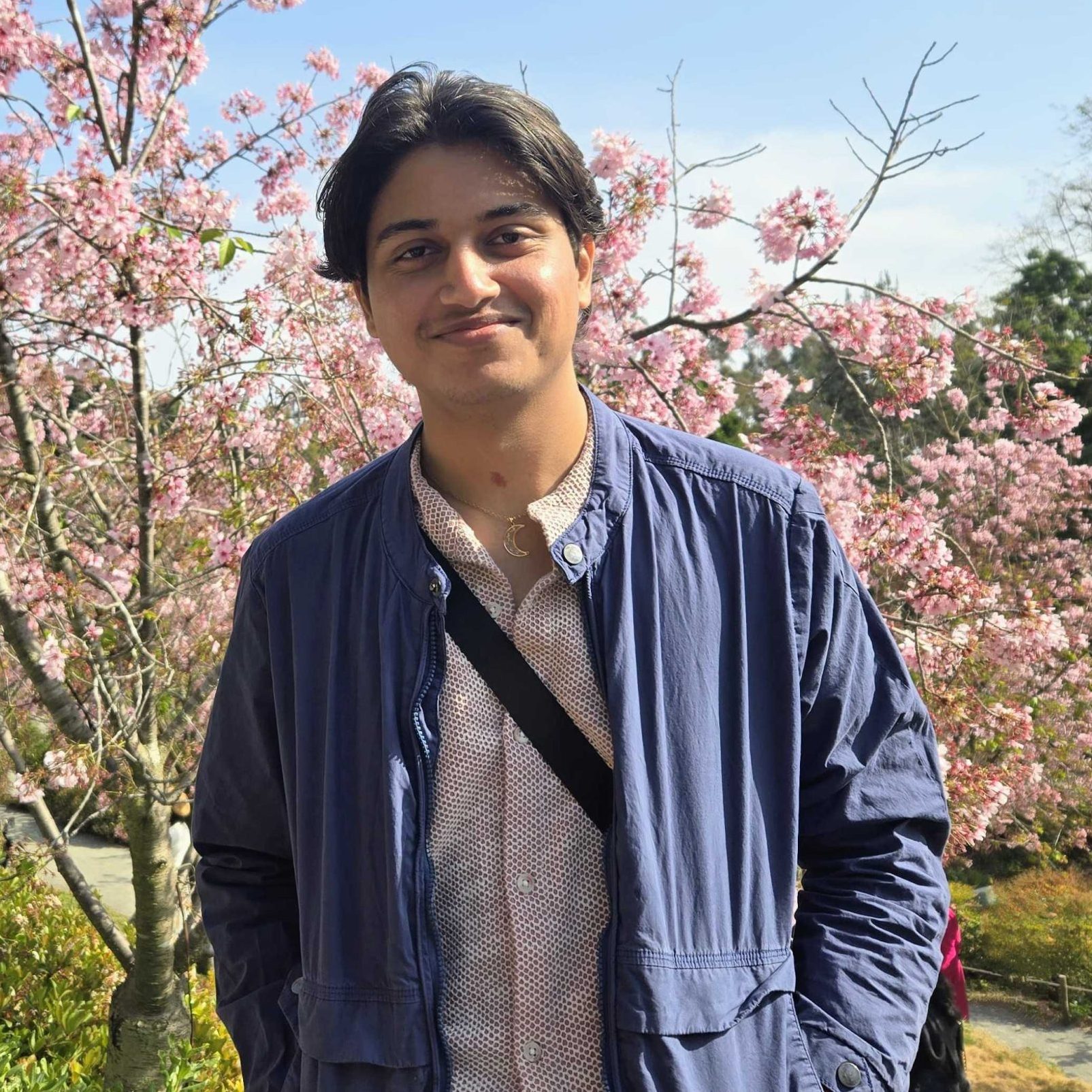 Headshot of research project pgrammer, Ashutosh Manoj, smiling standing outside in front of trees